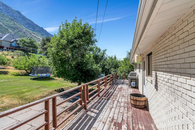 2040 N Oakcrest Ter, Provo, UT 84604 - wooden deck featuring a trampoline, a lawn, grilling area, and a mountain view