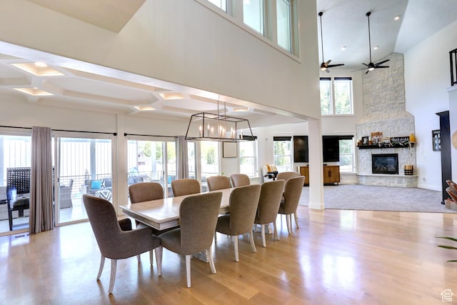 1767 S 800 W, Mapleton, UT 84664 - dining space with light wood-style flooring, a fireplace, a high ceiling, coffered ceiling, and a ceiling fan