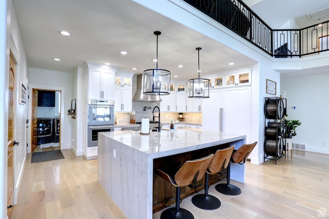 1767 S 800 W, Mapleton, UT 84664 - kitchen featuring double oven, light wood-type flooring, exhaust hood, a spacious island, and recessed lighting