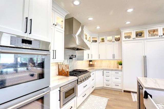 1767 S 800 W, Mapleton, UT 84664 - kitchen with wall chimney exhaust hood, built in appliances, light wood-style floors, white cabinets, and backsplash