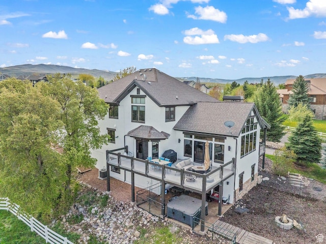 4555 Palomino Dr, Heber City, UT 84032 - back of house featuring roof with shingles, stucco siding, an outdoor living space with a fire pit, and a deck with mountain view