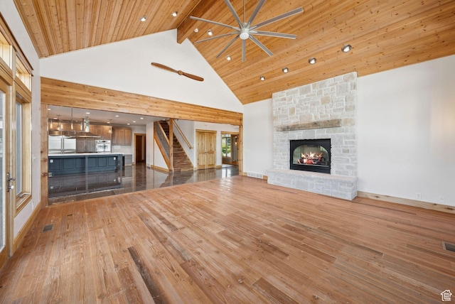 4555 Palomino Dr, Heber City, UT 84032 - unfurnished living room with stairs, high vaulted ceiling, a stone fireplace, wood-type flooring, and ceiling fan