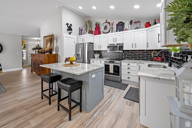 1343 W 870 N, Pleasant Grove, UT 84062 - kitchen featuring appliances with stainless steel finishes, backsplash, light wood-style flooring, a kitchen breakfast bar, and recessed lighting