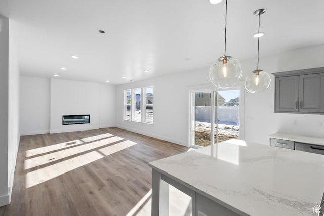 167 N 950 E Unit 30, Tremonton, UT 84337 - living room featuring light wood-style floors, a glass covered fireplace, and recessed lighting
