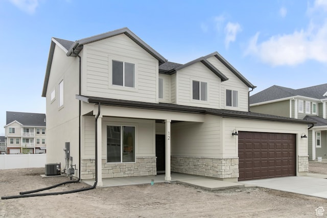 167 N 950 E Unit 30, Tremonton, UT 84337 - view of front of house featuring stone siding, a garage, driveway, and a porch