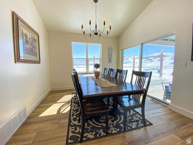 96 W 350 S, Garden City, UT 84028 - dining space with a chandelier, plenty of natural light, hardwood / wood-style floors, and vaulted ceiling