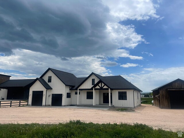 96 W 350 S, Garden City, UT 84028 - modern farmhouse featuring a garage, dirt driveway, a porch, and board and batten siding