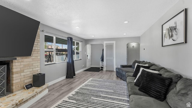5356 S 4280 W, Salt Lake City, UT 84118 - living area featuring a textured ceiling, arched walkways, light wood finished floors, and recessed lighting