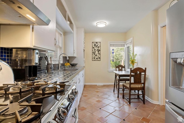 2664 S Melbourne St E, Salt Lake City, UT 84106 - kitchen with ventilation hood, stainless steel fridge, white cabinetry, stove, and backsplash