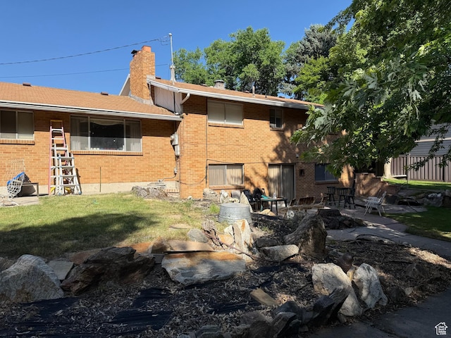 48 S Flint St, Kaysville, UT 84037 - rear view of property with brick siding, a chimney, a lawn, and a patio