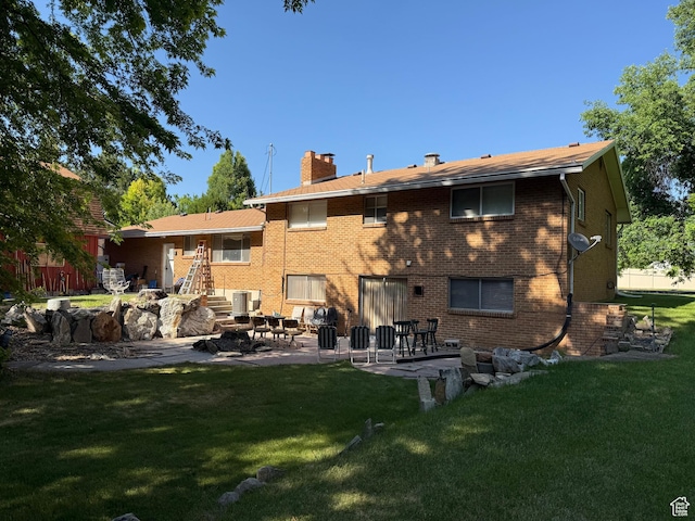 48 S Flint St, Kaysville, UT 84037 - rear view of house with a chimney, a patio area, a yard, and brick siding