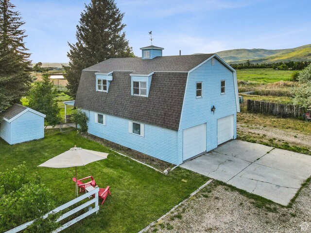 455 E Boulderville Rd, Oakley, UT 84055 - rear view of house with roof with shingles, a gambrel roof, an attached garage, concrete driveway, and a mountain view