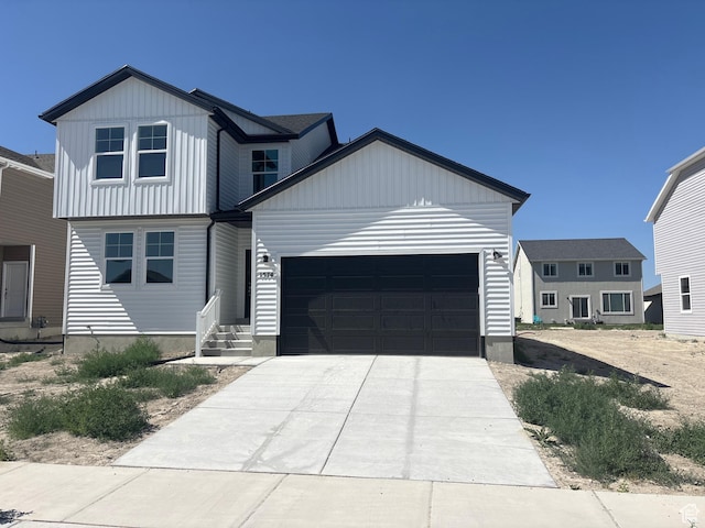 1574 E Pheasant Rd Unit 211, Eagle Mountain, UT 84005 - view of front facade with a garage, board and batten siding, and driveway