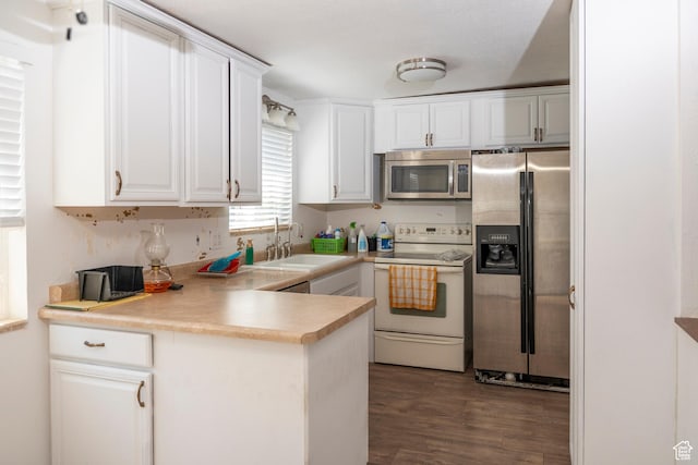 6867 S 1520 W, West Jordan, UT 84084 - kitchen with appliances with stainless steel finishes, white cabinetry, dark wood-type flooring, a peninsula, and light countertops