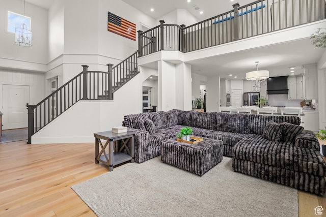 855 E Snap Dragon Ln, Fruit Heights, UT 84037 - living room featuring a chandelier, stairway, a towering ceiling, recessed lighting, and light wood-type flooring