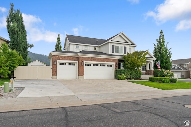 855 E Snap Dragon Ln, Fruit Heights, UT 84037 - view of front of home with a gate, concrete driveway, brick siding, a garage, and a mountain view