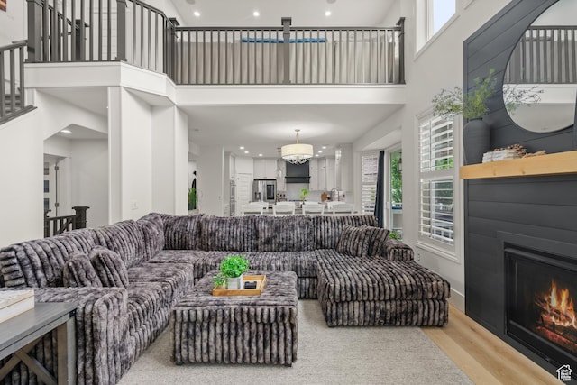 855 E Snap Dragon Ln, Fruit Heights, UT 84037 - living room featuring a towering ceiling, a glass covered fireplace, wood finished floors, and recessed lighting