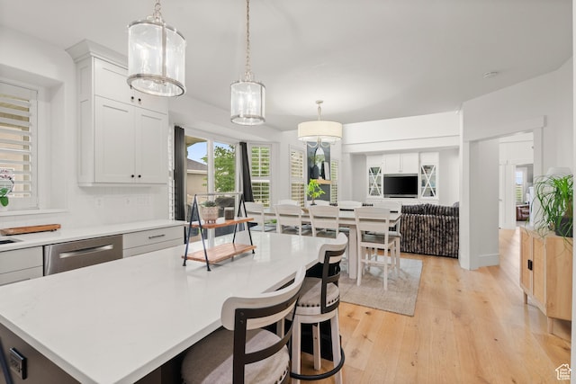 855 E Snap Dragon Ln, Fruit Heights, UT 84037 - kitchen with light countertops, light wood-style floors, decorative light fixtures, and stainless steel dishwasher