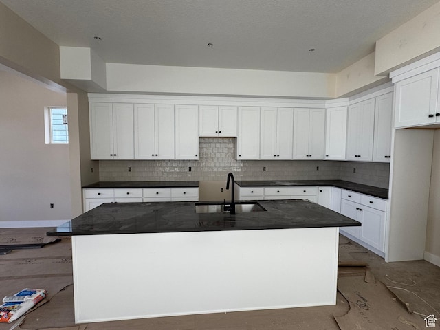 835 S 950 W Unit 124, Springville, UT 84663 - kitchen featuring dark countertops, backsplash, a kitchen island with sink, and white cabinetry
