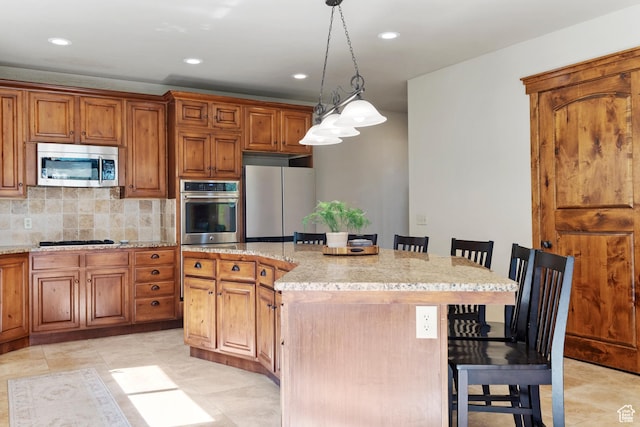1922 N 1550 E, Provo, UT 84604 - kitchen with appliances with stainless steel finishes, a breakfast bar area, recessed lighting, brown cabinetry, and decorative light fixtures