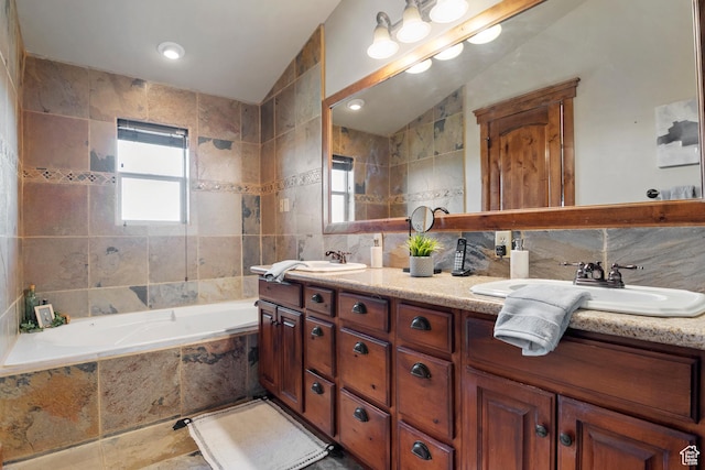 1922 N 1550 E, Provo, UT 84604 - bathroom with tile walls, double vanity, a relaxing tiled tub, vaulted ceiling, and backsplash