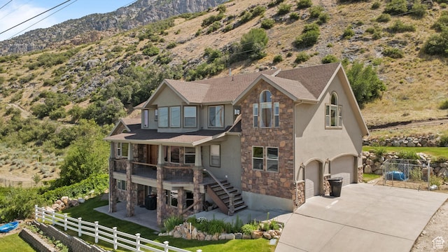 1922 N 1550 E, Provo, UT 84604 - view of front of property featuring stone siding, a mountain view, concrete driveway, an attached garage, and stairway