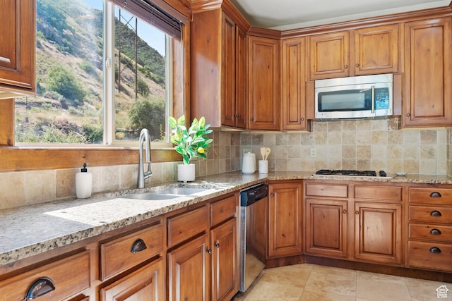 1922 N 1550 E, Provo, UT 84604 - kitchen with stainless steel appliances, brown cabinetry, backsplash, and light stone countertops