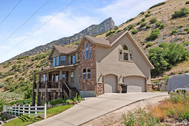 1922 N 1550 E, Provo, UT 84604 - view of front of property with stone siding, a mountain view, an attached garage, driveway, and stucco siding