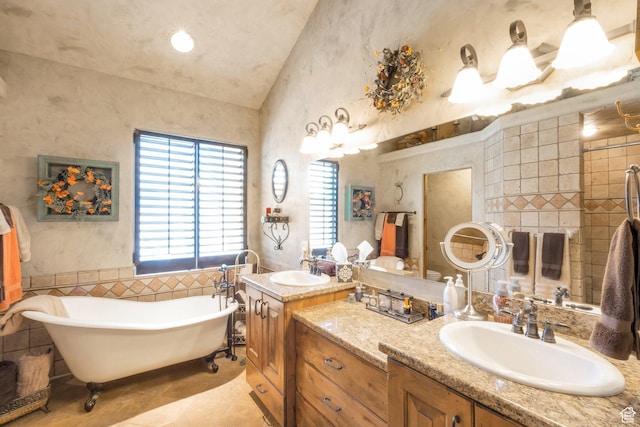 11273 S Alisa Meadows Dr, South Jordan, UT 84095 - full bathroom featuring vaulted ceiling, double vanity, a soaking tub, tile patterned flooring, and tile walls