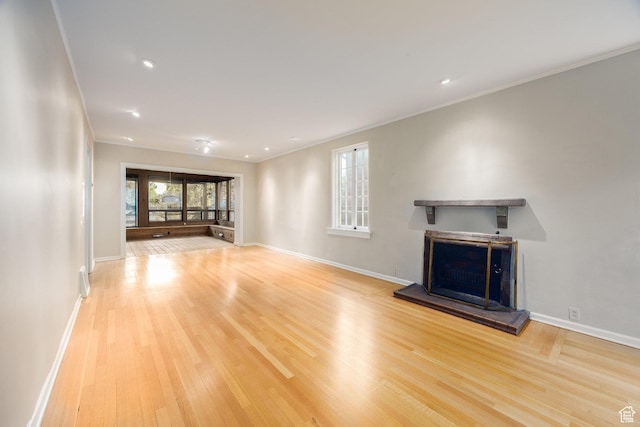 116 S University St E, Salt Lake City, UT 84102 - unfurnished living room featuring a fireplace with raised hearth, ornamental molding, wood finished floors, and recessed lighting