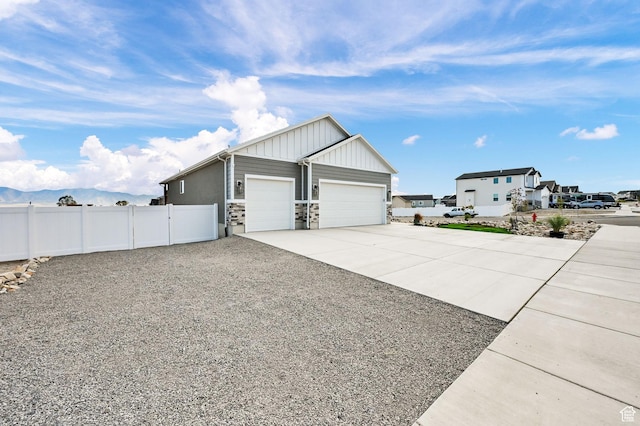 88 N Maraschino W, Grantsville, UT 84029 - view of property exterior featuring driveway, an attached garage, stone siding, board and batten siding, and a residential view