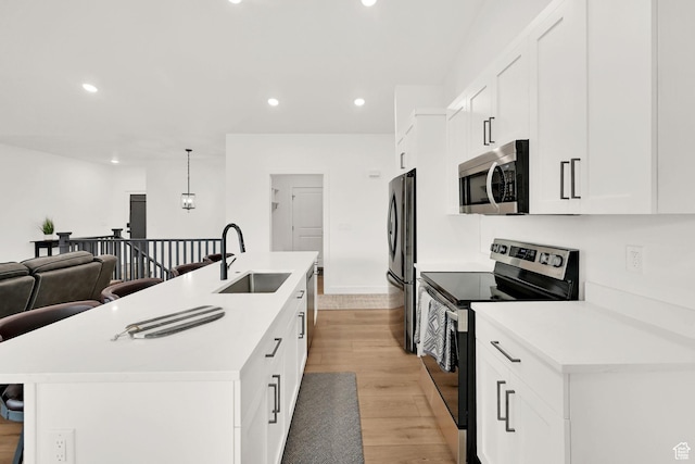 88 N Maraschino W, Grantsville, UT 84029 - kitchen featuring appliances with stainless steel finishes, recessed lighting, light wood-type flooring, a kitchen island with sink, and a kitchen bar
