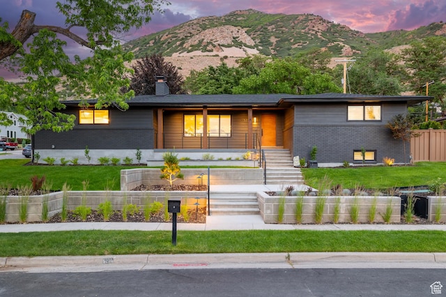 5223 S Hillsden Dr, Holladay, UT 84117 - view of front of house featuring brick siding, a chimney, a mountain view, and a front yard