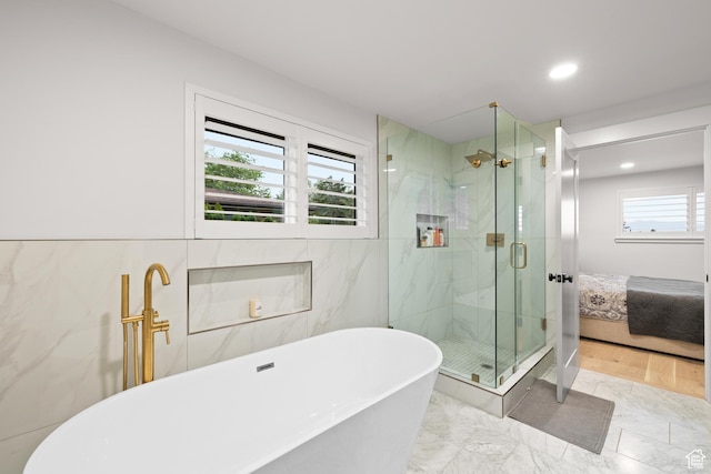 5223 S Hillsden Dr, Holladay, UT 84117 - ensuite bathroom with a soaking tub, a marble finish shower, marble finish flooring, recessed lighting, and tile walls