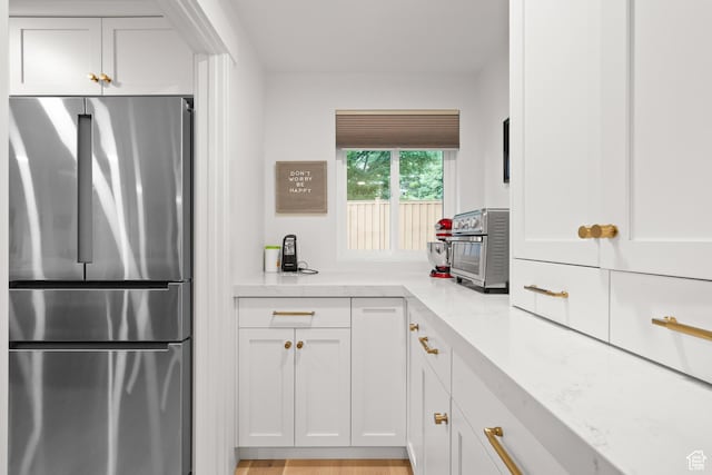 5223 S Hillsden Dr, Holladay, UT 84117 - kitchen with freestanding refrigerator, white cabinets, and light stone counters