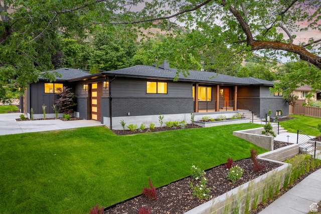 5223 S Hillsden Dr, Holladay, UT 84117 - view of front facade with a vegetable garden, brick siding, an attached garage, and covered porch