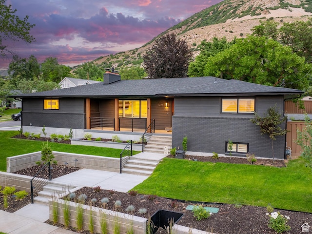 5223 S Hillsden Dr, Holladay, UT 84117 - view of front facade with brick siding, a front lawn, a chimney, and a mountain view