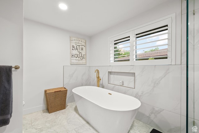 5223 S Hillsden Dr, Holladay, UT 84117 - bathroom featuring marble look tile flooring, a freestanding bath, tile walls, and recessed lighting