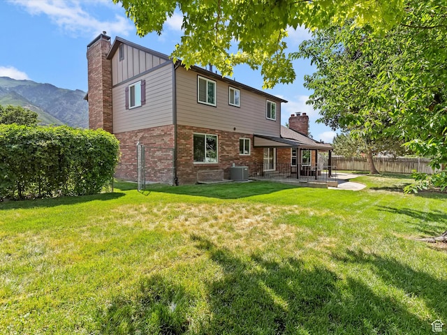 2203 N Joni Dr E, Layton, UT 84040 - back of property with a patio area, board and batten siding, a chimney, and brick siding