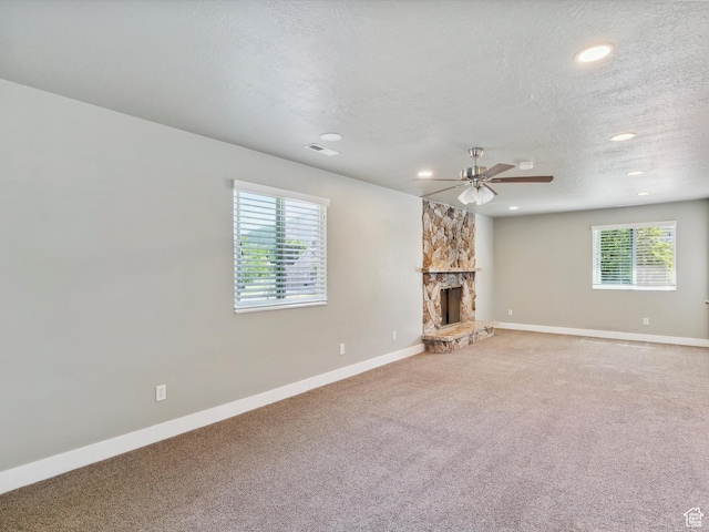 2203 N Joni Dr E, Layton, UT 84040 - unfurnished living room featuring light colored carpet, ceiling fan, a fireplace, recessed lighting, and a textured ceiling