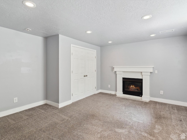 2203 N Joni Dr E, Layton, UT 84040 - unfurnished living room featuring carpet, a textured ceiling, recessed lighting, and a glass covered fireplace