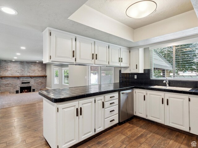2203 N Joni Dr E, Layton, UT 84040 - kitchen with stainless steel dishwasher, a peninsula, dark wood-style floors, white cabinets, and recessed lighting