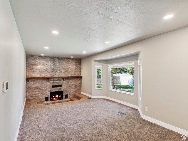 2203 N Joni Dr E, Layton, UT 84040 - unfurnished living room with carpet floors, recessed lighting, a fireplace, and a textured ceiling