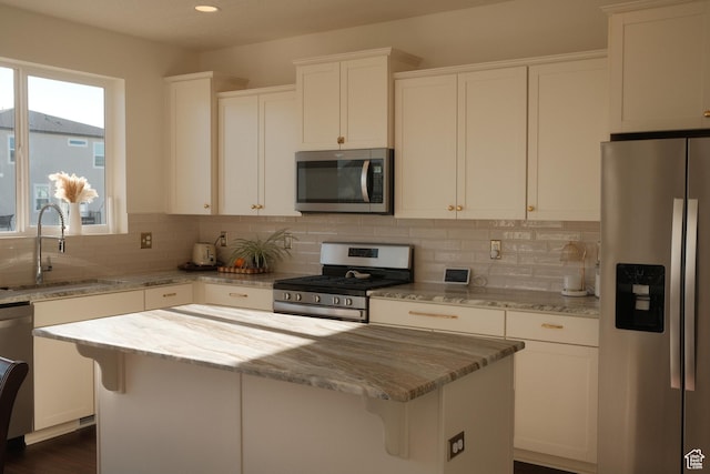 5071 N Oak Creek Dr, Eagle Mountain, UT 84005 - kitchen featuring appliances with stainless steel finishes, light stone counters, backsplash, a center island, and white cabinetry