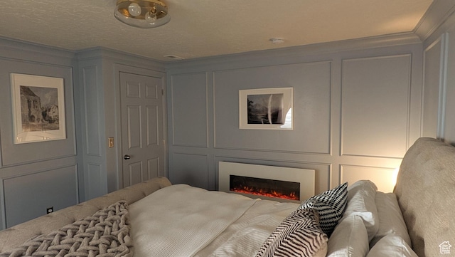 5071 N Oak Creek Dr, Eagle Mountain, UT 84005 - bedroom with a decorative wall, ornamental molding, and a lit fireplace