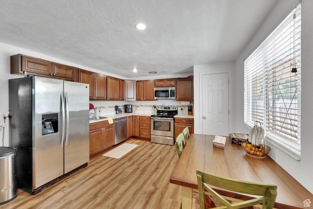 3567 S 3400 W, West Valley City, UT 84119 - kitchen featuring stainless steel appliances, light countertops, light wood-type flooring, a textured ceiling, and recessed lighting