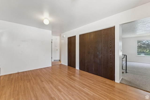 6113 S Vineway Cir, Salt Lake City, UT 84121 - unfurnished bedroom featuring light wood-type flooring and multiple closets
