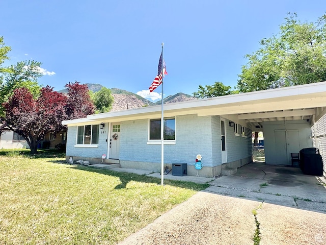 641 E 925 N, Ogden, UT 84404 - view of front of house featuring concrete driveway, a front yard, brick siding, a mountain view, and a carport