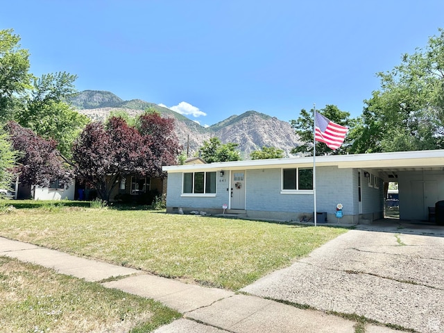 641 E 925 N, Ogden, UT 84404 - view of front of house featuring a mountain view, a front lawn, concrete driveway, a carport, and brick siding