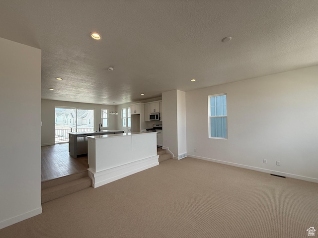 6923 W S Jordan Pkwy S, South Jordan, UT 84009 - kitchen featuring stainless steel appliances, recessed lighting, a kitchen island, white cabinets, and light carpet